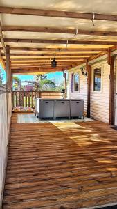 un gran patio con suelo de madera y mesa en Mobil home 6 personnes camping 4* Les Pins Maritimes en Hyères