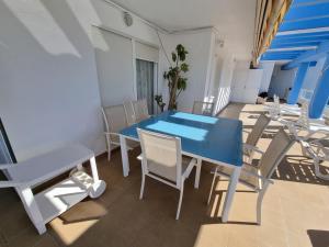 Ático en Costa Ballena con Barbacoa, Aire Acondicionado y WIFI في كوستا بالينا: غرفة طعام مع طاولة وكراسي زرقاء