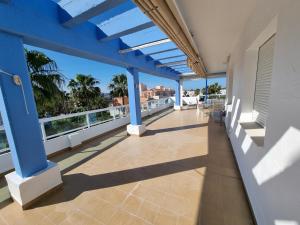 a balcony with blue columns and a view of the ocean at Ático en Costa Ballena con Barbacoa, Aire Acondicionado y WIFI in Costa Ballena