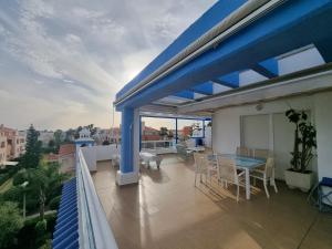 a balcony with a blue roof with a table and chairs at Ático en Costa Ballena con Barbacoa, Aire Acondicionado y WIFI in Costa Ballena