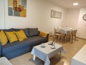 ein Wohnzimmer mit einem blauen Sofa und einem Tisch in der Unterkunft Apartamento Bolboretas con parking privado in Ares
