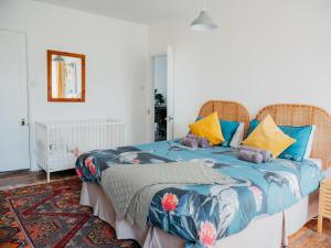 ファルマスにあるEnchanted Rose Garden Houseのベッドルーム1室(青と黄色の枕が備わるベッド1台付)
