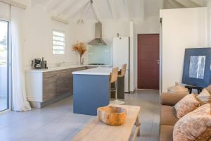 a kitchen and living room with a couch and a table at Maison Palmier Blanc in Saint Barthelemy