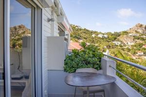 a balcony with a table and a view of the mountains at Maison Palmier Blanc in Saint Barthelemy +9 photos