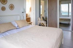 a bedroom with a white bed and a view of the ocean at Maison Palmier Blanc in Saint Barthelemy