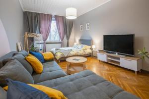 uma sala de estar com um sofá e uma televisão de ecrã plano em Justi Old Town Apartment Studencka em Cracóvia