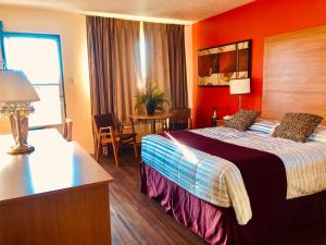 pokój hotelowy z łóżkiem z pomarańczową ścianą w obiekcie Martin's Inn w mieście Cornwall