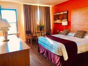 a hotel room with a bed with an orange wall at Martin's Inn in Cornwall