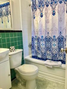 a bathroom with a toilet and a blue and white shower curtain at Martin's Inn in Cornwall