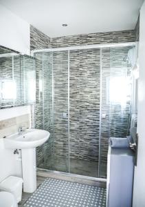 uma casa de banho com um lavatório e uma cabina de duche em vidro. em Casa Elizabeth em Xàbia