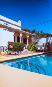 a swimming pool with benches and a house at Casa Elizabeth in Jávea