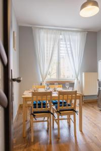 uma sala de jantar com uma mesa e cadeiras e uma janela em Justi Old Town Apartment Studencka em Cracóvia
