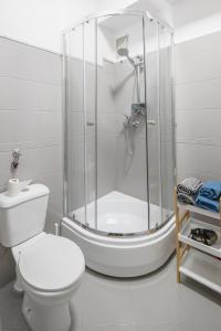 uma casa de banho branca com um chuveiro e um WC. em Justi Old Town Apartment Studencka em Cracóvia