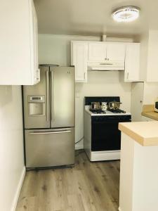 a kitchen with a stainless steel refrigerator and a stove at 2 Bd Beverly Hills Guest House in Los Angeles