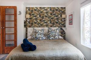 um quarto com uma cama com cobertores e almofadas azuis em Art Box em Greyton