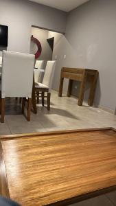 comedor con sillas blancas y mesa de madera en Alma wine House B en Maipú