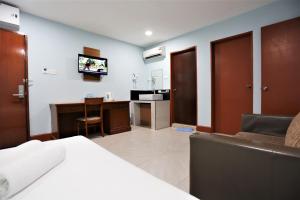 Dormitorio con cama, escritorio y TV en ORKID Hills at Pudu, en Kuala Lumpur