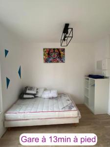1 dormitorio con 1 cama y una foto en la pared en Au coeur de Noyon, en Noyon