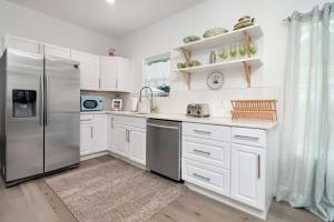 a kitchen with white cabinets and a stainless steel refrigerator at The Mason House in Georgetown