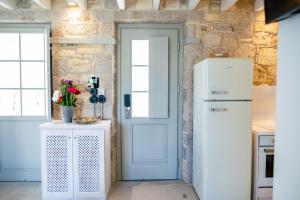 een keuken met een koelkast en een tafel met bloemen bij The Windmill Villa in Lampi