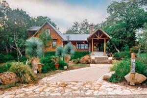 a log home with a pathway leading to the front door at Beacon Log Cabin in Austin