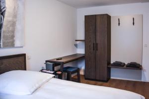 a bedroom with a desk and a bed and a cabinet at Hotel Pame Grill in Eching