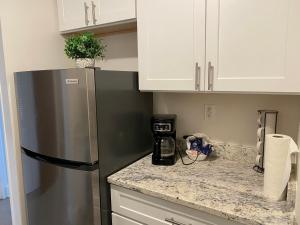 a kitchen with a stainless steel refrigerator and white cabinets at Quaint studio apartment in Gadsden, Al in Gadsden +2 photos