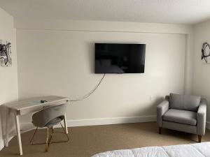 1 dormitorio con escritorio, silla y TV en la pared en Quaint studio apartment in Gadsden, Al en Gadsden