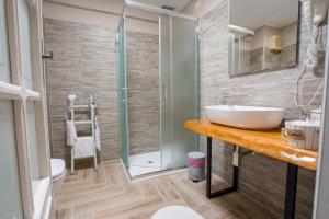een badkamer met een wastafel en een douche bij Domo 'e sa rosa in Bosa