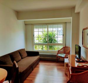 uma sala de estar com um sofá e uma grande janela em Apartamentos Sanxenxo Progreso 140 em Sanxenxo