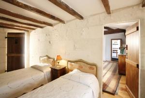 a bedroom with two beds and a table with a lamp at La Porte Rouge - The Red Door Inn in Saintes