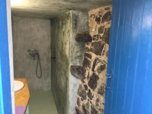 a bathroom with a shower with a stone wall at Olympos Traditional House in Olympos