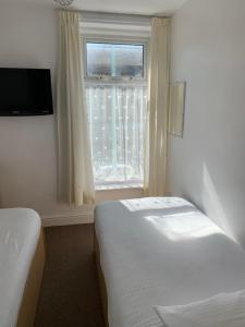 ブラックプールにあるDelamere holiday flatのベッド2台と窓が備わるホテルルームです。