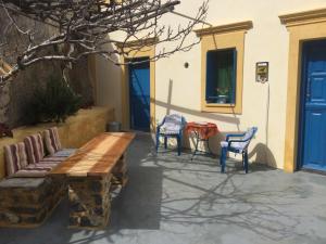a patio with a wooden bench and two chairs at Olympos Traditional House in Olympos