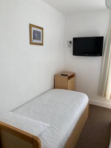 1 dormitorio con 1 cama y TV de pantalla plana en Delamere holiday flat, en Blackpool