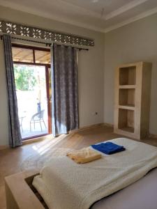 een slaapkamer met een groot bed en een groot raam bij Villa Pumziko in Kizimkazi