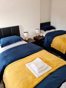2 łóżka w pokoju w kolorze niebieskim i żółtym w obiekcie Family Home w Liverpoolu