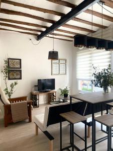 a living room with a table and a tv at Apartamentos La Muralla in Santo Domingo de la Calzada