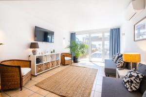 a living room with a couch and a tv at Stunning terrace with ocean view in Albufeira