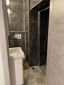 uma casa de banho com um lavatório e uma parede de azulejos pretos em Luxury Penthouse in Nişantaşı em Istambul