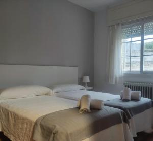um quarto com 2 camas e uma janela em Apartamentos Sanxenxo Progreso 140 em Sanxenxo