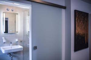 a bathroom with a sink and a mirror at Hotel Pame Grill in Eching