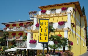 Un edificio giallo con un cartello che dice "Hog oh a hotel" di Hotel Capri Bardolino 3S a Bardolino