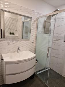 a white bathroom with a shower and a sink at Apartment ILLARIA in Rijeka