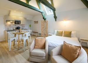 a bedroom with a bed and a table and chairs at Villa Forestière Studio l'Olivier in Quincy-Voisins