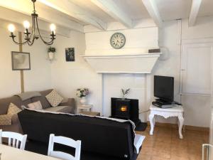 ein Wohnzimmer mit einem Sofa und einem Kamin in der Unterkunft Gîte des Lavandes in Oradour-Fanais
