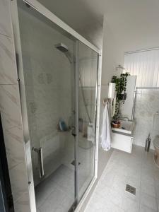 baño con ducha y puerta de cristal en István Vendégház - Zsóryfürdő en Szihalom