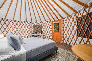 ein Schlafzimmer in einer Jurte mit einem Bett und einem Tisch in der Unterkunft OT 3515E Texas Yurt Haus 5 Yurts in New Braunfels