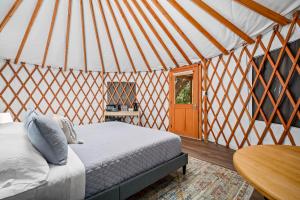 a bedroom in a yurt with a bed and a table at OT 3515E Texas Yurt Haus 5 Yurts in New Braunfels