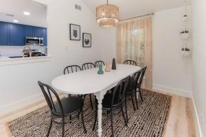 une salle à manger avec une table blanche et des chaises noires dans l'établissement The Willow, à Round Rock